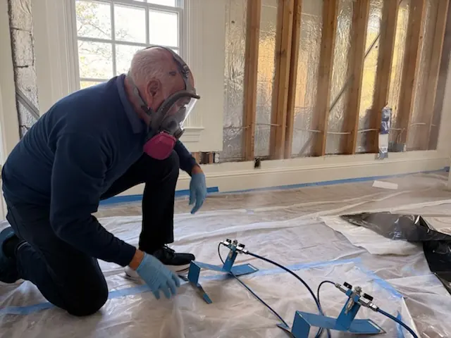 A restoration technician setting drying equipment in a Boise home stripped to the studs